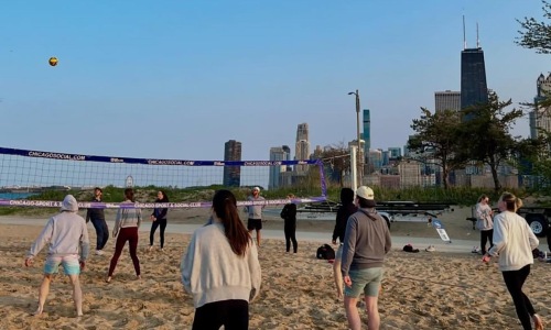 people playing volleyball on a beach