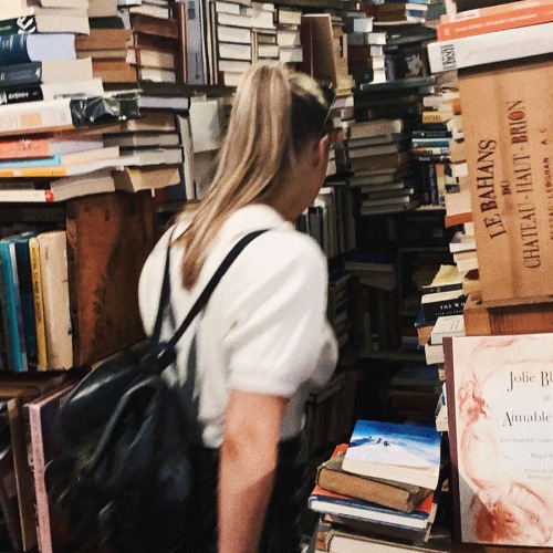 lady walking through stacks of books